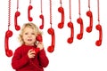 Adorable child with many red phones hanging of a cable Royalty Free Stock Photo