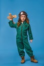 adorable child in pilot costume with wooden plane toy