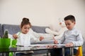 Adorable children sitting at table and drawing using color pencils. Concept of education at home Royalty Free Stock Photo