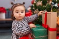 Adorable chinese toddler decorating christmas tree at home