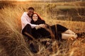 Adorable couple lay at the field, attractive husband gently hug adorable wife, overjoyed woman smiling, happy family