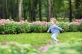 Adorable curly baby girl running in a beautiful park