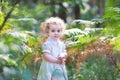 Adorable curly baby girl in sunny park