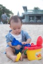 Adorable  Cute Asian baby boy playing with beach toys on tropical beach Royalty Free Stock Photo