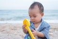 Adorable Cute  Asian baby boy playing with beach toys on tropical beach Royalty Free Stock Photo
