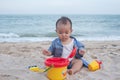 Adorable  Cute Asian baby boy playing with beach toys on tropical beach Royalty Free Stock Photo