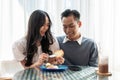 Adorable cute Asian couple having a lovely date at a cafe, having food and drinks