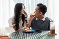 Adorable cute Asian couple having a lovely date at a cafe, having food and drinks