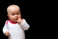 Adorable and cute baby girl with her finger in the mouth. Infant on the black background and the space for text Royalty Free Stock Photo