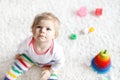 Adorable cute beautiful little baby girl playing with educational colorful wooden rainboy toy pyramid Royalty Free Stock Photo