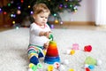 Adorable cute beautiful little baby girl playing with educational colorful wooden rainboy toy pyramid Royalty Free Stock Photo