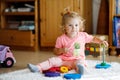 Adorable cute beautiful little baby girl playing with educational colorful wooden rainboy toy pyramid Royalty Free Stock Photo