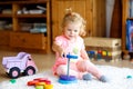 Adorable cute beautiful little baby girl playing with educational colorful wooden rainboy toy pyramid Royalty Free Stock Photo