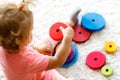 Adorable cute beautiful little baby girl playing with educational colorful wooden rainboy toy pyramid Royalty Free Stock Photo