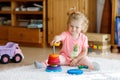 Adorable cute beautiful little baby girl playing with educational colorful wooden rainboy toy pyramid Royalty Free Stock Photo