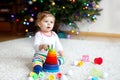 Adorable cute beautiful little baby girl playing with educational colorful wooden rainboy toy pyramid Royalty Free Stock Photo