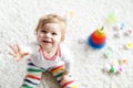 Adorable cute beautiful little baby girl playing with educational colorful wooden rainboy toy pyramid Royalty Free Stock Photo