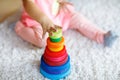 Adorable cute beautiful little baby girl playing with educational colorful wooden rainboy toy pyramid Royalty Free Stock Photo