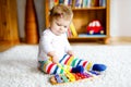 Adorable cute beautiful little baby girl playing with educational toys at home or nursery. Happy healthy child having Royalty Free Stock Photo