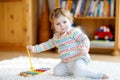 Adorable cute beautiful little baby girl playing with educational wooden music toys at home or nursery. Toddler with Royalty Free Stock Photo