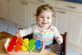 Adorable cute beautiful little baby girl playing with educational wooden music toys at home or nursery Royalty Free Stock Photo