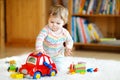 Adorable cute beautiful little baby girl playing with educational wooden toys at home or nursery. Toddler with colorful Royalty Free Stock Photo