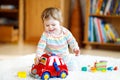 Adorable cute beautiful little baby girl playing with educational wooden toys at home or nursery. Toddler with colorful Royalty Free Stock Photo
