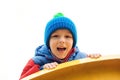 Adorable cute boy playing on playground on a cold day. Child wearing funny hat and red jacket. Funny little boy outdoors. Kids out Royalty Free Stock Photo