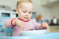 Adorable cute caucasian blond toddler boy eating tasty vegetable soup in chair at kithcen indoor. Mother feeding baby healthy food Royalty Free Stock Photo