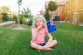 Adorable cute happy Caucasian girl holding Australian flag. Smiling child sitting on grass in park holding Australia flag. Kid Royalty Free Stock Photo