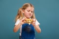 Adorable cute little girl in white shirt and jean jumpsuit with hamburger Royalty Free Stock Photo