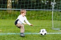 Adorable cute little kid boy playing soccer and football on field Royalty Free Stock Photo