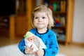 Adorable cute little toddler girl playing with doll. Happy healthy baby child having fun with role game, playing mother Royalty Free Stock Photo