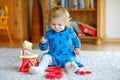 Adorable cute little toddler girl playing with doll. Happy healthy baby child having fun with role game, playing mother Royalty Free Stock Photo