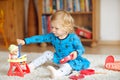 Adorable cute little toddler girl playing with doll. Happy healthy baby child having fun with role game, playing mother Royalty Free Stock Photo