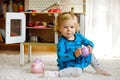 Adorable cute little toddler girl playing with toy kitchen Happy healthy baby child having fun with role game, playing Royalty Free Stock Photo