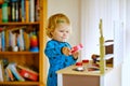Adorable cute little toddler girl playing with toy kitchen Happy healthy baby child having fun with role game, playing Royalty Free Stock Photo