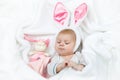 Adorable cute newborn baby girl in Easter bunny costume and ears. Lovely child playing with plush rabbit toy. Holiday Royalty Free Stock Photo