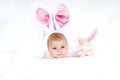 Adorable cute newborn baby girl in Easter bunny costume and ears. Lovely child playing with plush rabbit toy. Holiday Royalty Free Stock Photo