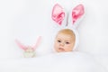 Adorable cute newborn baby girl in Easter bunny costume and ears. Lovely child playing with plush rabbit toy. Holiday Royalty Free Stock Photo