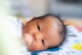 The adorable cute newborn baby infant with big black eyes lying on the bed Royalty Free Stock Photo