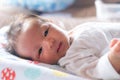 The adorable cute newborn baby infant with big black eyes lying on the bed and smilling Royalty Free Stock Photo