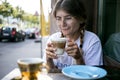 Cute pretty young woman drinks coffee milk foam Royalty Free Stock Photo