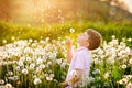 Adorable cute school boy blowing on a dandelion flower on the nature in the summer. Happy healthy beautiful child with Royalty Free Stock Photo