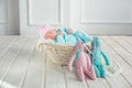 Adorable cute sweet baby girl sleeping in white basket on wooden floor with two toy tilda rabbits Royalty Free Stock Photo