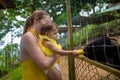 Adorable cute toddler girl with mother feeding goat on a kids farm. Beautiful baby child petting animals in the zoo. Excited and Royalty Free Stock Photo