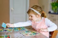 Adorable cute toddler girl playing picture card game. Happy healthy child training memory, thinking. Creative indoors