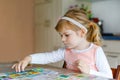 Adorable cute toddler girl playing picture card game. Happy healthy child training memory, thinking. Creative indoors Royalty Free Stock Photo