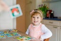 Adorable cute toddler girl playing picture card game. Happy healthy child training memory, thinking. Creative indoors Royalty Free Stock Photo