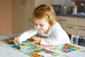 Adorable cute toddler girl playing picture card game at home or nursery. Happy healthy child training memory, thinking Royalty Free Stock Photo